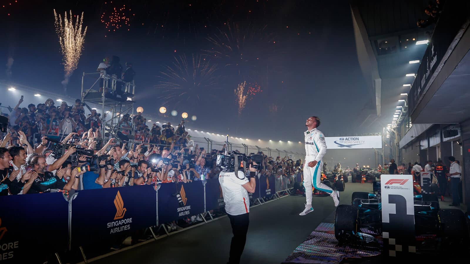 Lewis Hamilton leaps off his Mercedes F1 car after winning 2018 Singapore Grand Prix