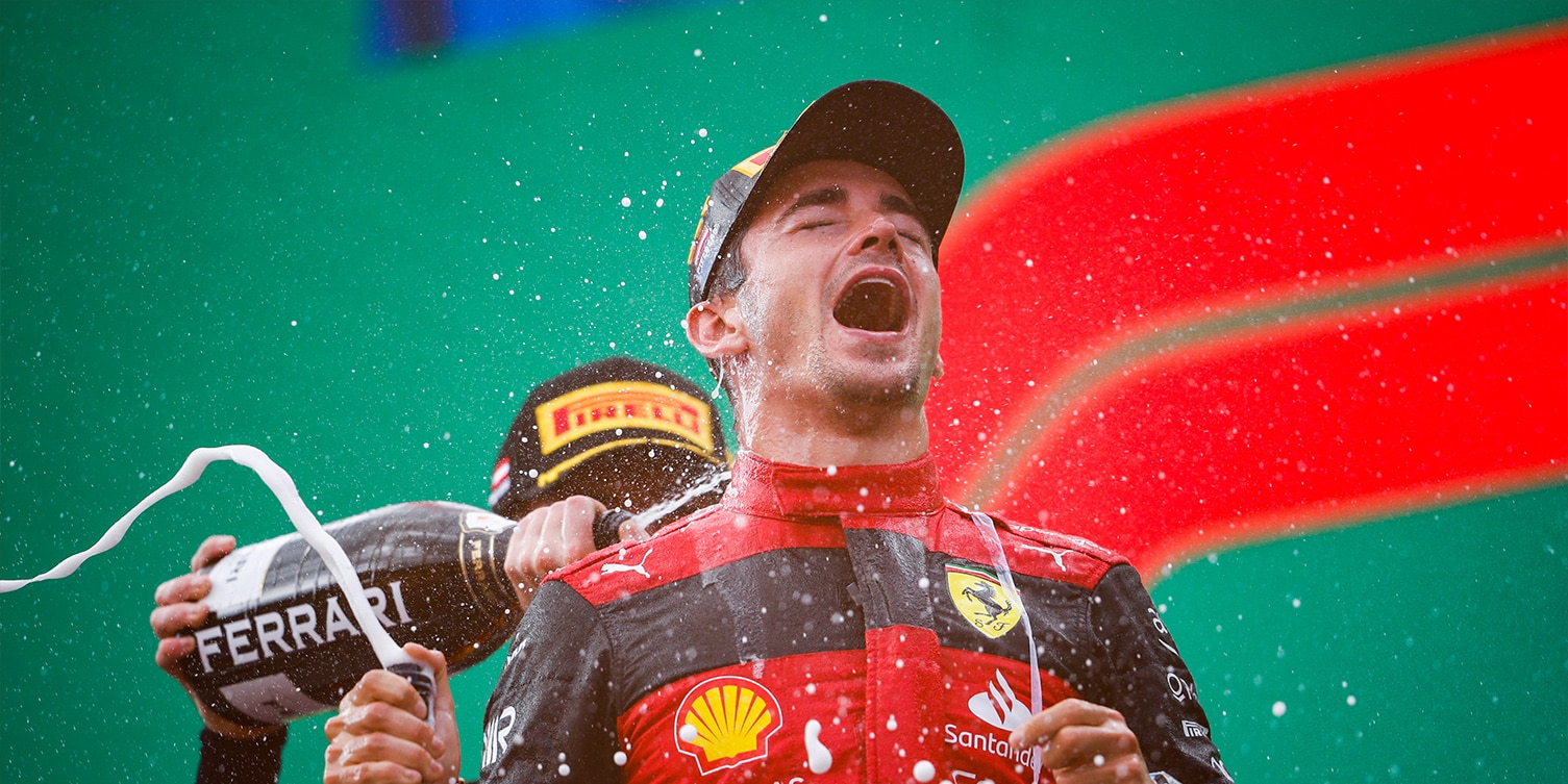 Lewis Hamilton sprays Charles Leclerc with champagne on the podium after the 2022 Austrian Grand Prix