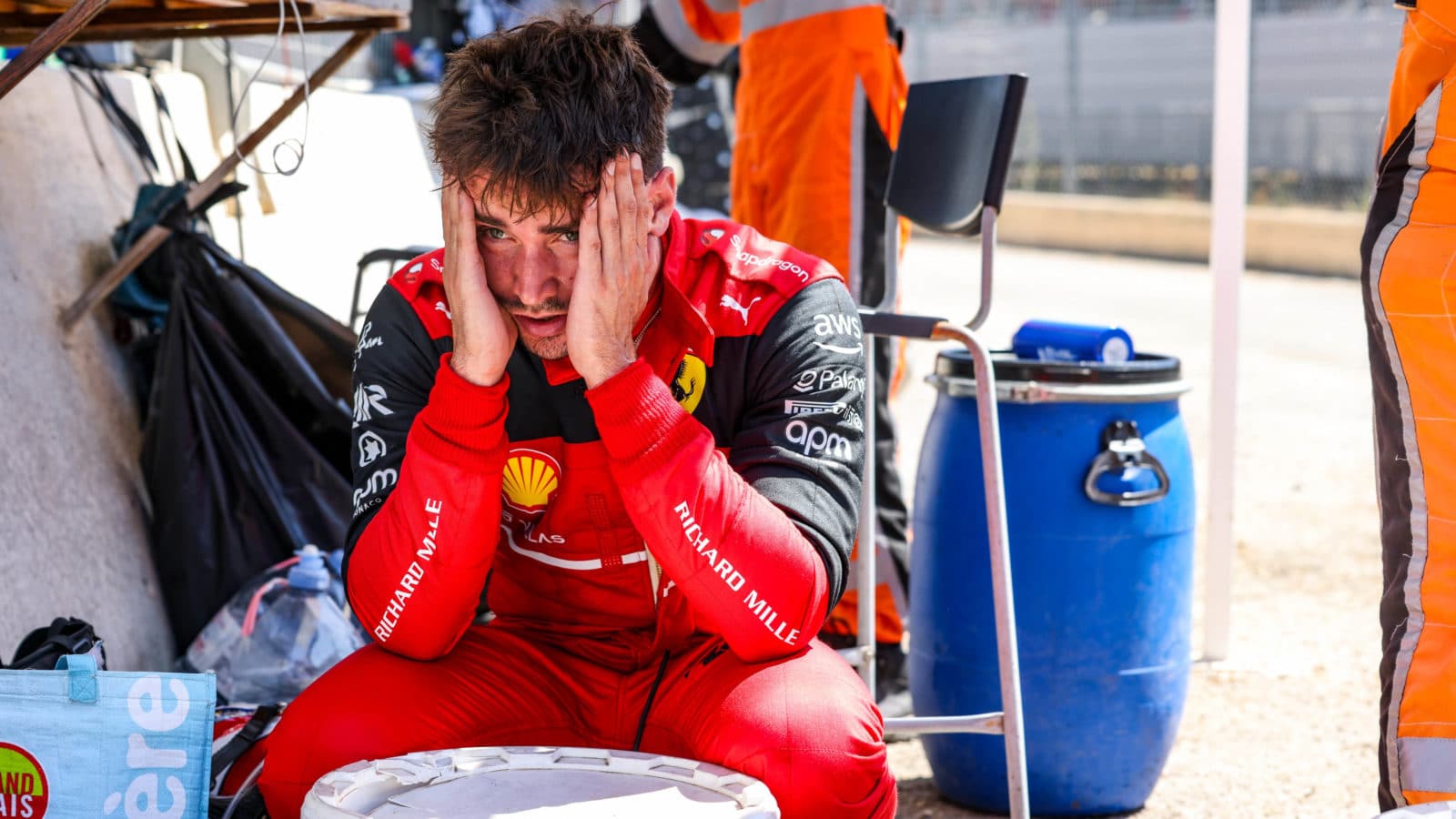 Charles Leclerc holds his face in his hands after crashing out of the 2022 French Grand Prix