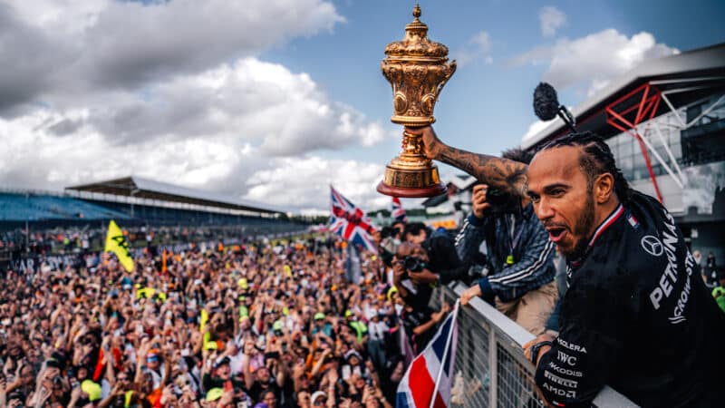 Lewis Hamilton holds up British Grand Prix trophy in front of Silverstone crowd after winning the 2024 race