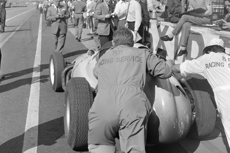 Stirling Moss is pushed out of the pit lane in his BRM P25.