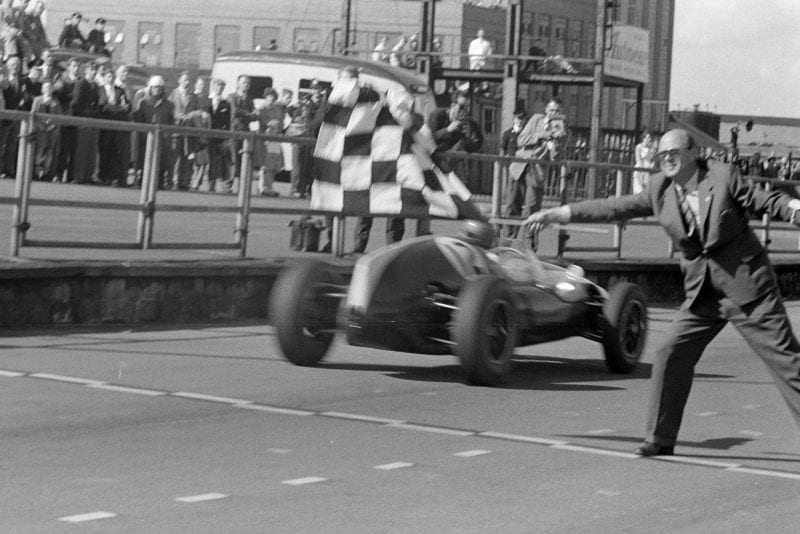 Jack Brabham, Cooper T51 Climax, takes the chequered flag for victory.