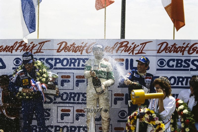 Michele Alboreto, 1st position, celebrates on the podium with Keke Rosberg, 2nd position, and John Watson, 3rd position on the podium.