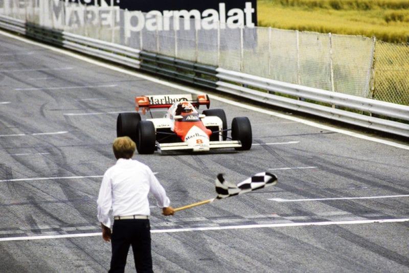 Niki Lauda in his McLaren MP4-2 TAG, crosses the finish line and takes the chequered flag to become the first Austrian driver to win the Austrian Grand Prix during the Austrian GP at Red Bull Ring.