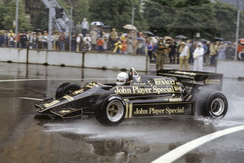 Elio de Angelis, Lotus 93T Renault, splashes through a puddle.
