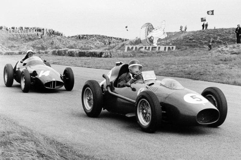 Mike Hawthorn driving the Ferrari Dino 246 in 5th position, leads Jean Behra, BRM P25 in 3rd position