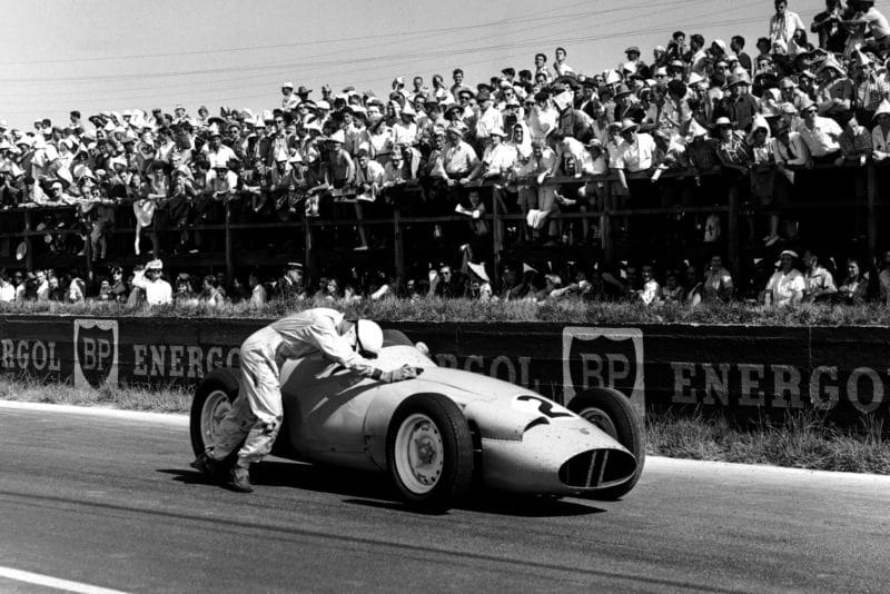 Stirling Moss pushes his BRM P25 , but is later disqualified for receiving outside assistance.