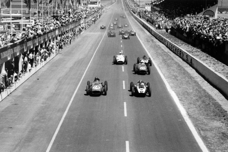 Tony Brooks, #24 Ferrari Dino 246 and Jack Brabham, Cooper T51-Climax, lead at the start.