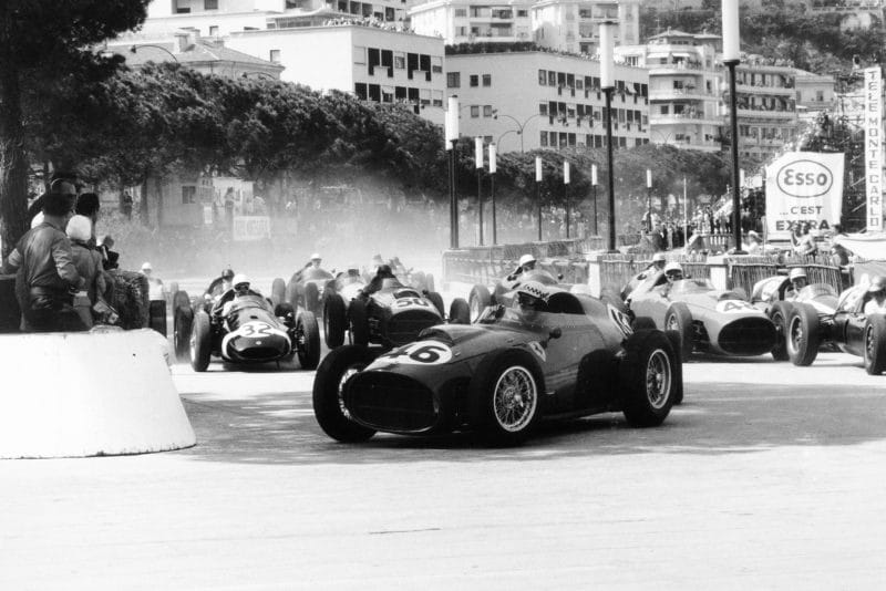 Jean Behra driving a Ferrari Dino 246, leads Stirling Moss in his Cooper T51-Climax and Jack Brabham driving Cooper T51-Climax at the start of the race.