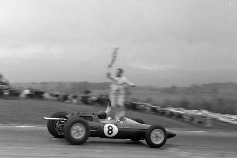 Jim Clark, Lotus 25 Climax, takes the chequered flag.