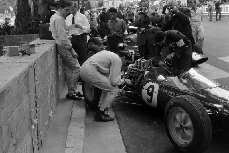 Jim Clark works on his Lotus 25 Climax in the pits