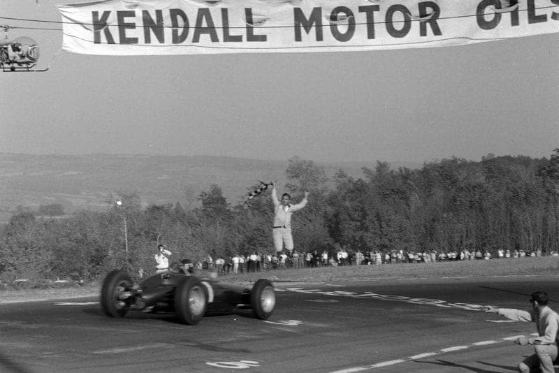 Graham Hill, BRM P57, crosses the finish line to finish 3rd.