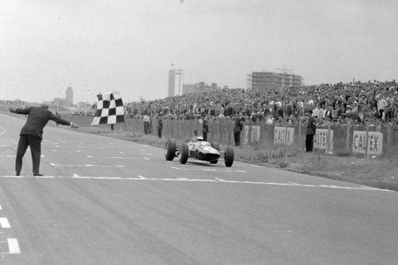 Jim Clark, Lotus 33 Climax, takes the chequered flag for victory.