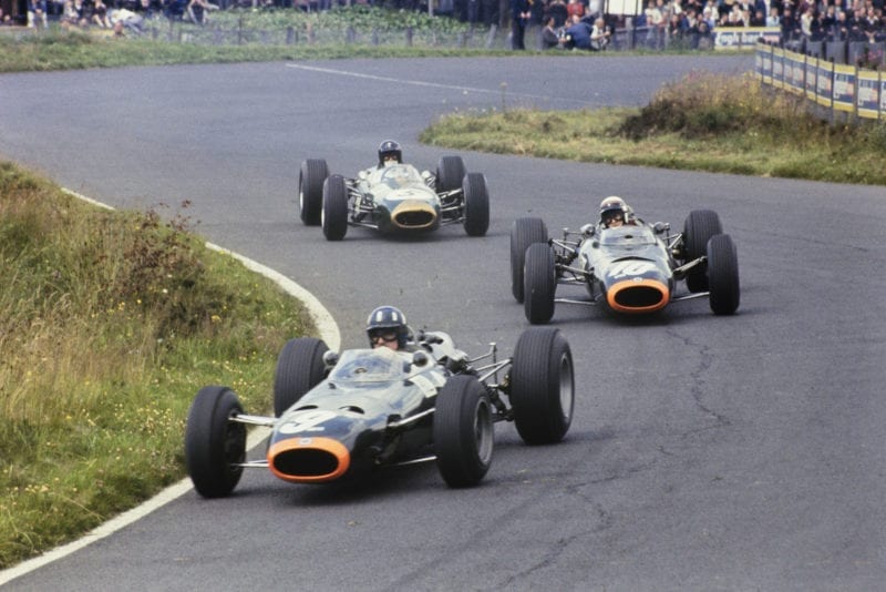 Graham Hill, BRM P261, leads Jackie Stewart, BRM P261, and Dan Gurney, Brabham BT11 Climax.