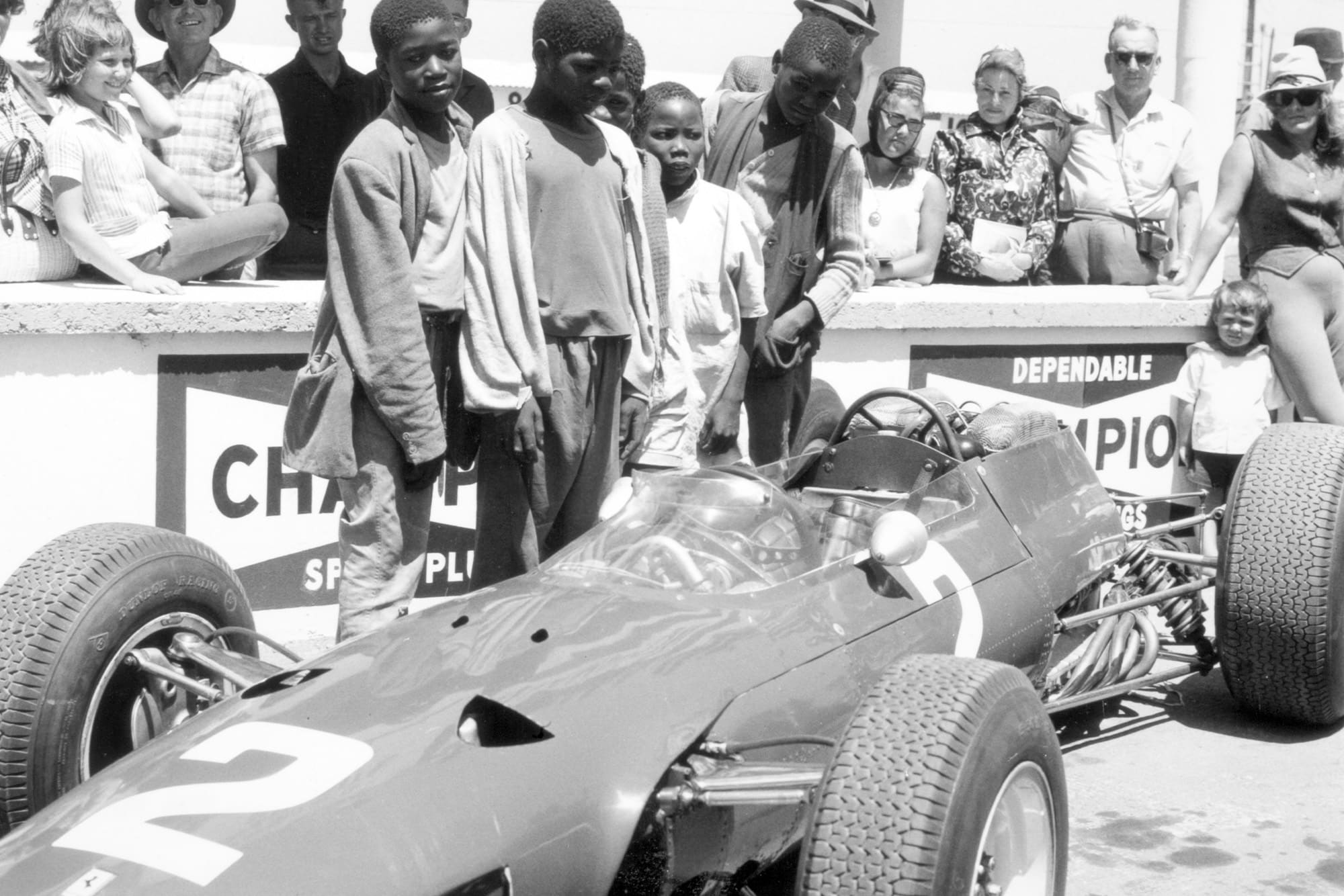 The local crowd gather in the pits to see the cars close up.