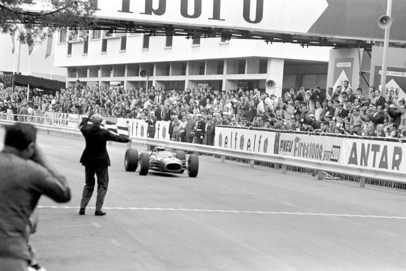 Denny Hulme (NZL) Brabham BT20 takes the chequered flag to win the Monaco Grand Prix.