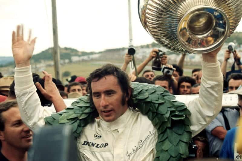 Jackie Stewart celebrates on the podium after winning the 1969 South African Grand Prix.