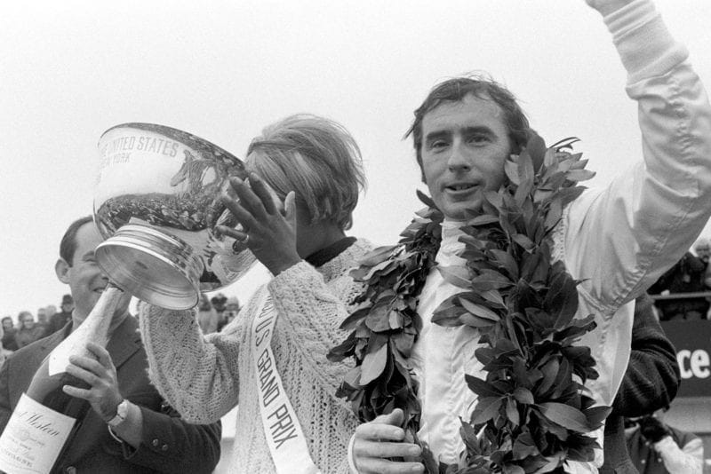 Jackie Stewart celebrates on the podium at the 1968 United States Grand Prix.