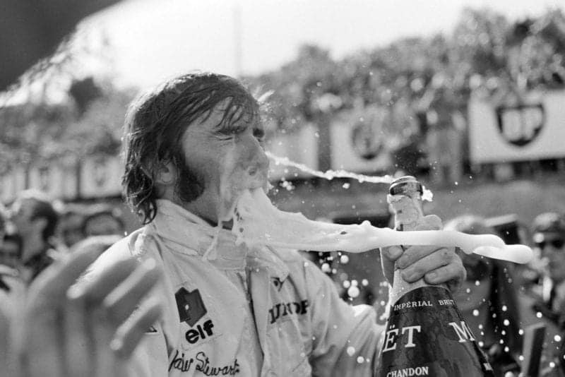 Jackie Stewart celebrates on the podium after winning the 1969 French Grand Prix