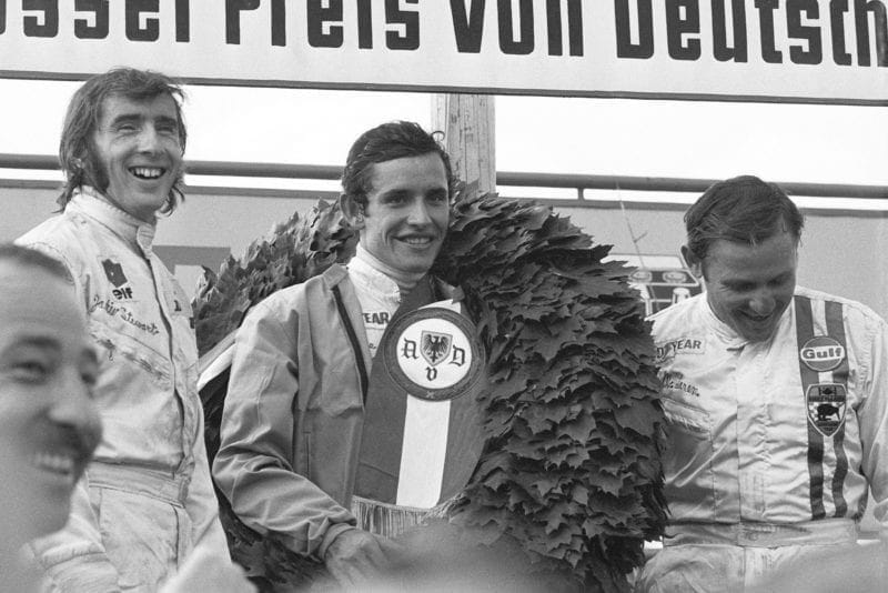 Jacky Ickx stands on the podium after winning the 1969 German Grand Prix