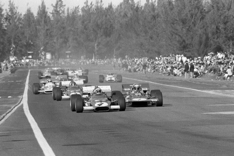 Clay Regazzoni's Ferrari leads the field on the opening lap of the Mexican Grand Prix.