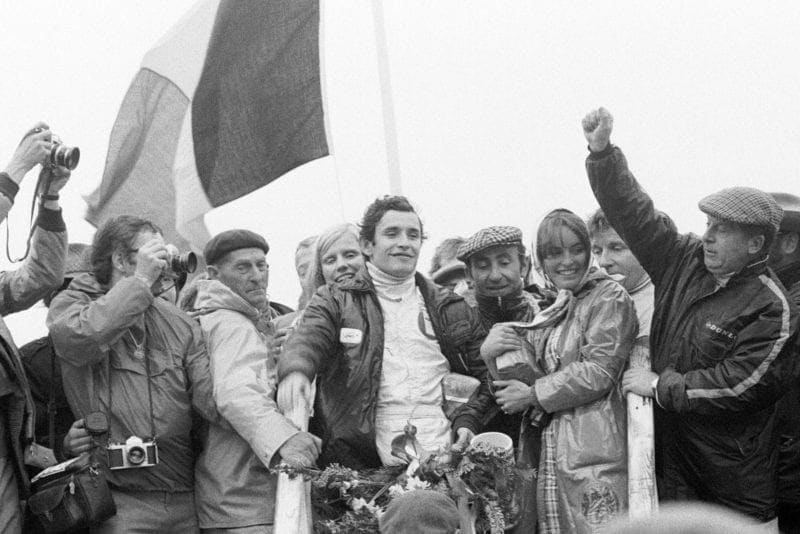 Jacky Ickx celebrates his win on the podium after emerging victorious at the 1971 Dutch Grand Prix.