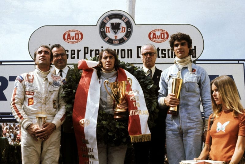 Jackie Stewart stands on the podium in between Clay Regazzoni (left) and Francois Cevert (right).
