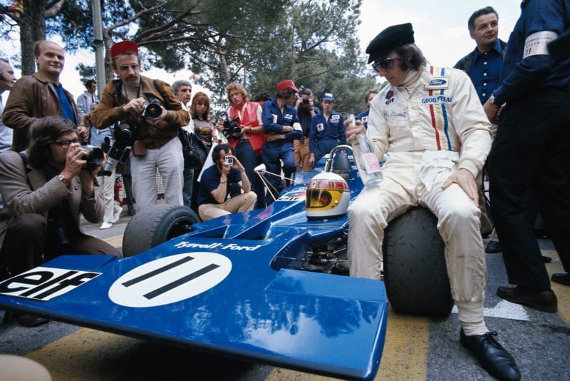 Jackie Stewart sits on the wheel of his Tyrrell before the 1971 Monaco Grand Prix.