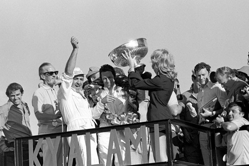 Mario Andretti celebrates on the podium after winning the 1971 South African Grand Prix.