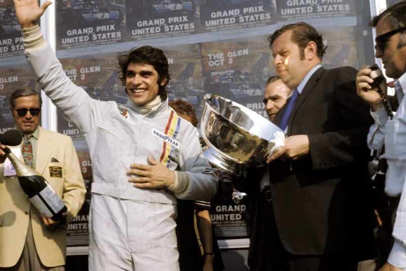 Francois Cevert celebrates his first win on the podium at the 1971 United States Grand Prix.