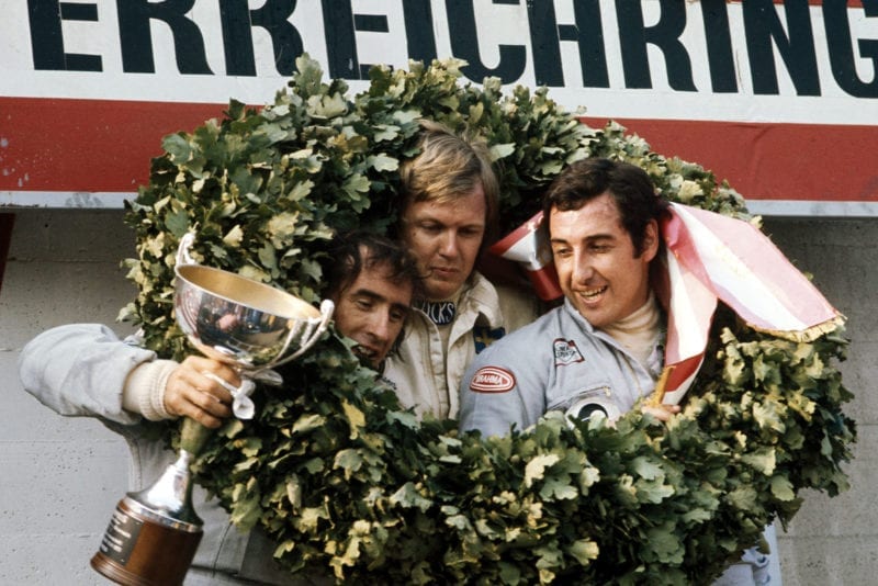 Ronnie Peterson (centre), Jackie Stewart (left) and Carlos Pace (right) celebrate on the podium at the 1973 Austrian Grand Prix.