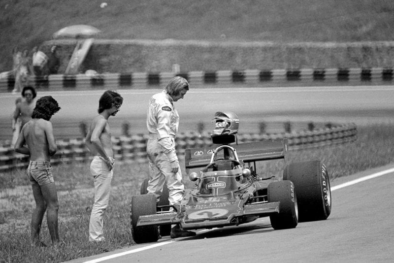 Ronnie Peterson inspects his Lotus car after retiring from the 1973 Brazilian Grand Prix.