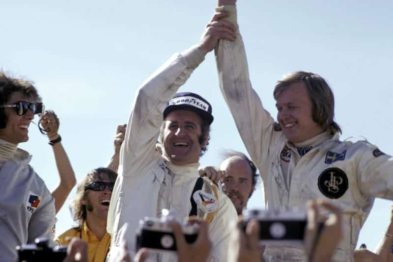 Denny Hulme (McLaren) and Ronnie Peterson (Lotus) celebrate on the podium.