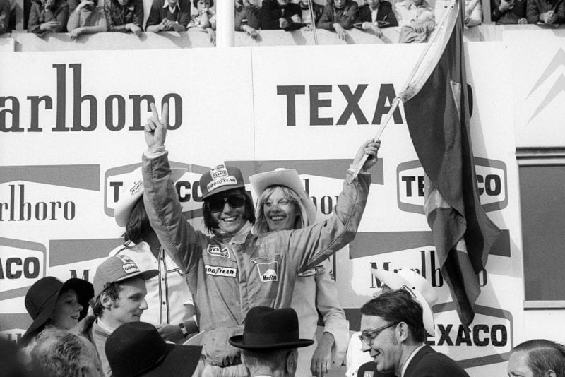 Emerson Fittipaldi celebrates his win on the podium at the 1974 Brazilian Grand Prix