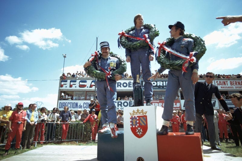 Ronnie Peterson stands on the top step of the podium after winning the 1974 French Grand Prix, Paul Ricard.