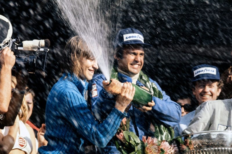 Carlos Reutemann celebrates on the podium afterw inning the 1974 South African Grand Prix.