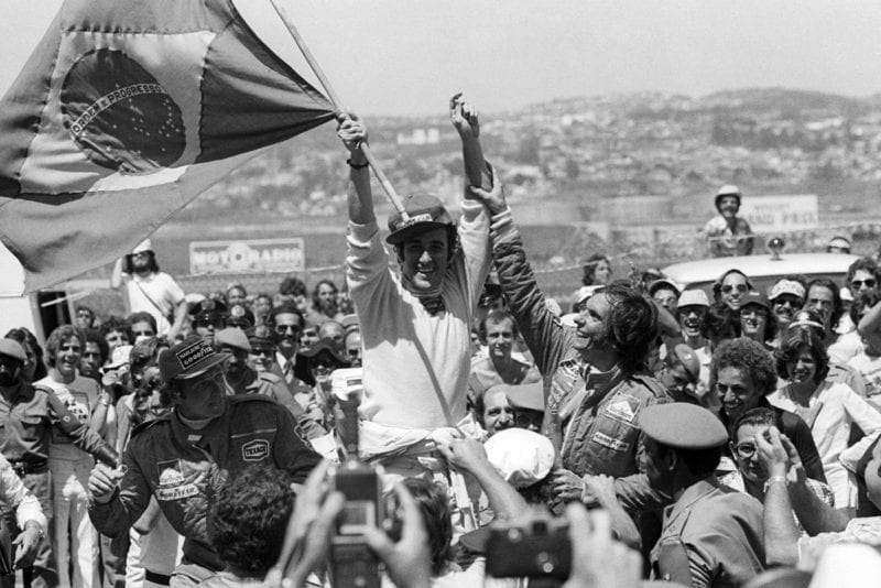 Carlos Pace (Brabham) raises the Brazilian flag aloft as he celebrates winning the 1975 Brazilian Grand Prix.