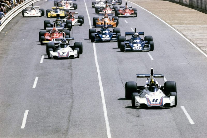 Carlos Pace leads the pack at the start of the 1975 South African Grand Prix, Kyalami.