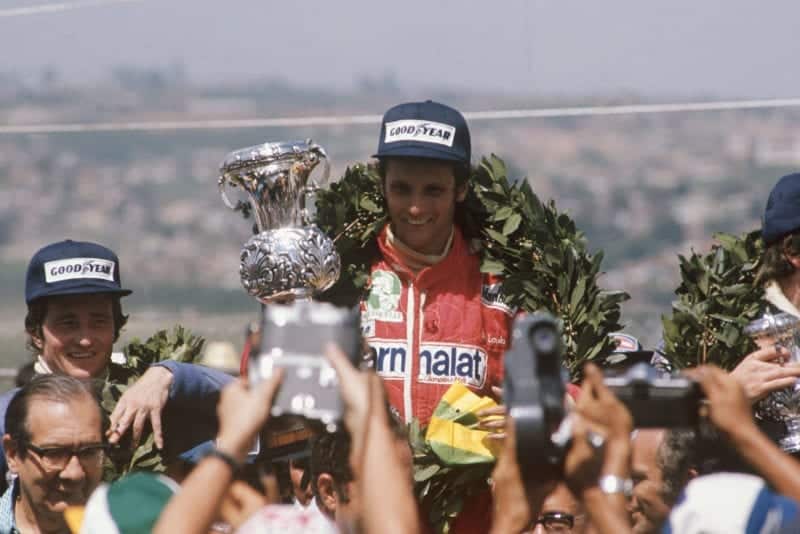Niki Lauda stands atop the podium after winning the 1976 Brazilian Grand Prix