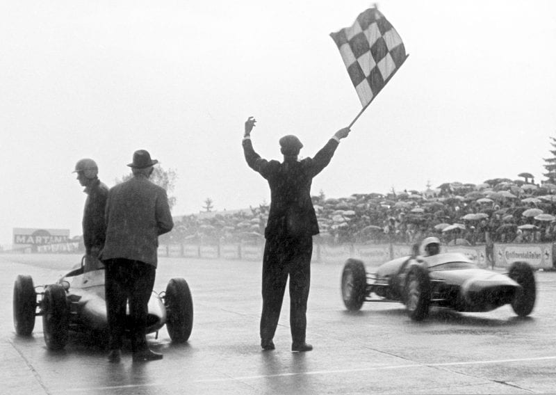 Stirling Moss takes the flag in his Lotus 18/21-Climax.