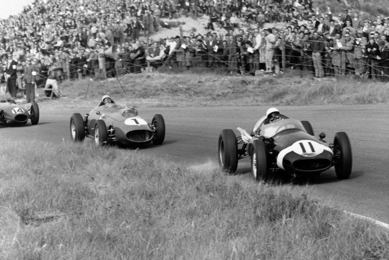 Stirling Moss driving the Cooper T51-Climax leads Jean Behra in his Ferrari Dino 246 and Graham Hill in a Lotus 16-Climax.