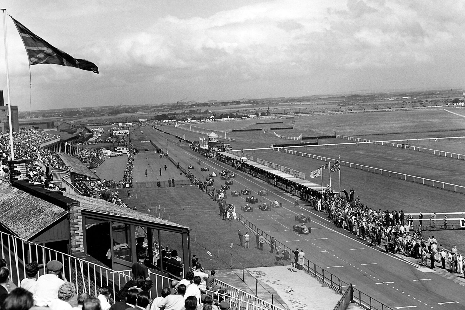 Stirling Moss in the BRM P25 passes Bruce McLaren in his Cooper-Climax T45.