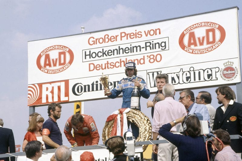 Jacques Laffite (Ligier JS11/15-Ford Cosworth), 1st position. Also visable on the podium are Carlos Reutemann (Williams FW07B-Ford Cosworth), 2nd position and FISA President Jean-Marie Balestre.