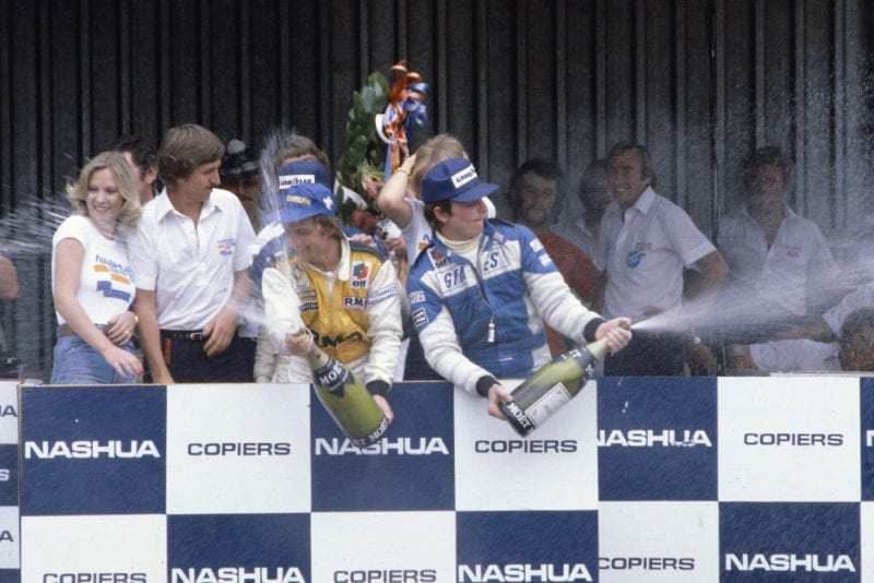 Rene Arnoux (Equipe Renault) celebrates his 1st position on the podium with Patrick Depailler (Ligier Ford) 3rd position.