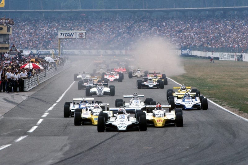 Alan Jones in his Williams FW07B, leads into the first corner at the start of the race.