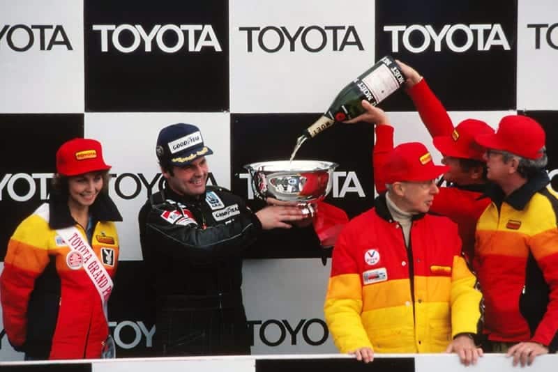 Race winner Alan Jones (Williams) celebrates his victory with champagne on the podium