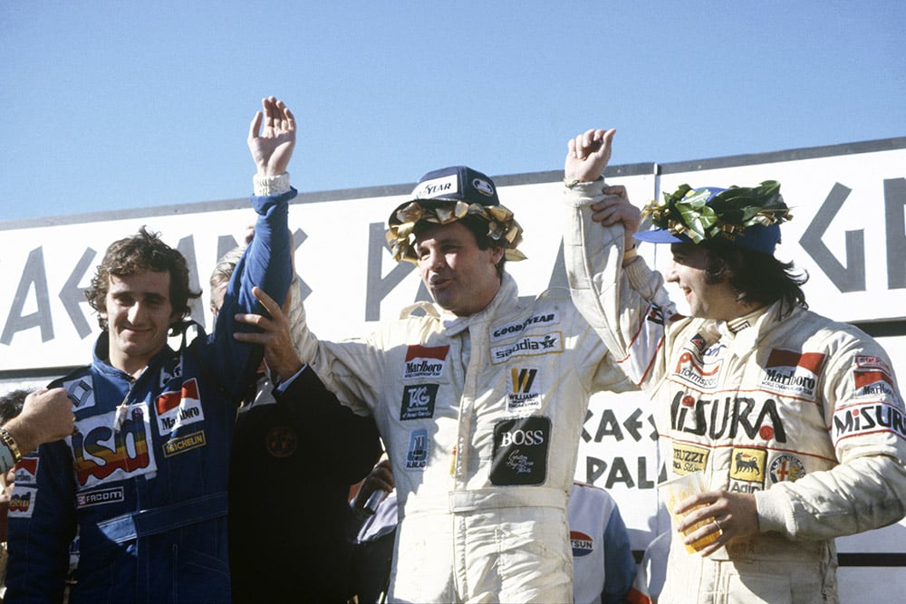 Winner Alan Jones celebrates on the podium with second placed Alain Prost and third placed Bruno Giacomelli.