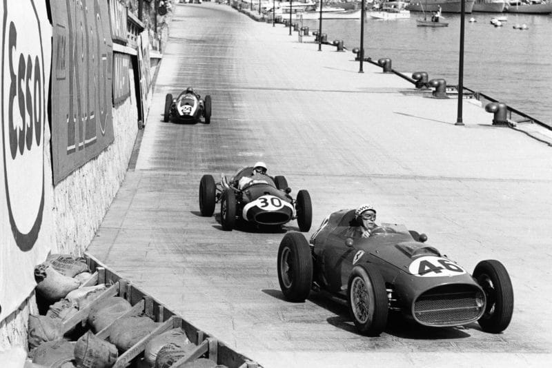 Jean Behra in his Ferrari Dino 246 leads Stirling Moss in a Cooper T51-Climax and Jack Brabham also in aCooper T51-Climax.