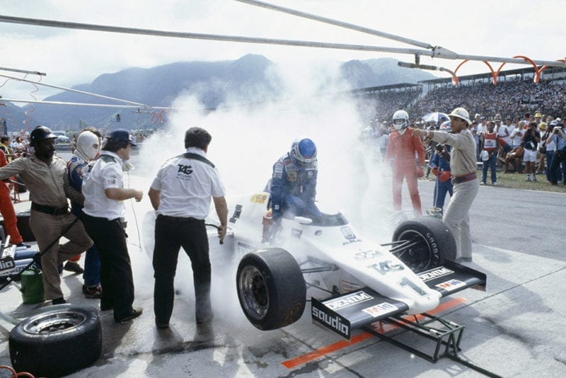 Keke Rosberg (Williams FW08C Ford) during a disastrous pitstop, where a small amount of spilt fuel caused a flash-fire which was promptly extinguished by marshals. He returned to his cockpit to finish 2nd but was disqualified for a push start after this stop.