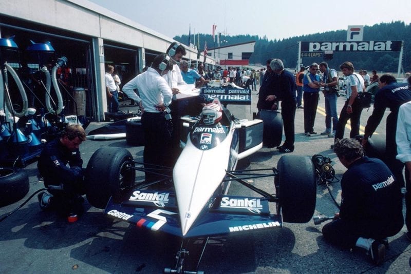 The Brabham of Nelson Piquet recieves some attention from his mechanics in the pits.